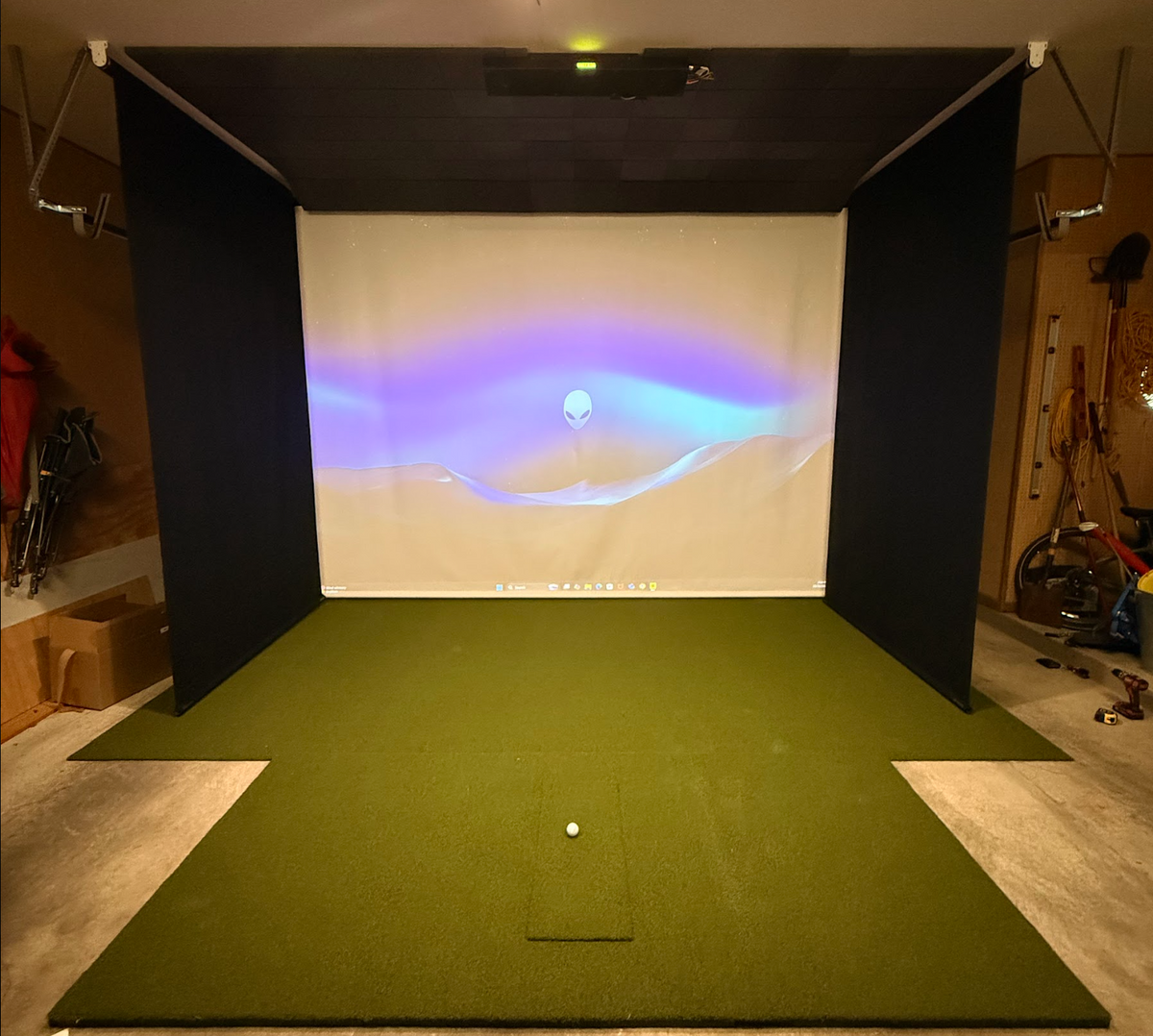 Retractable impact screen with black side panels set up in a home garage